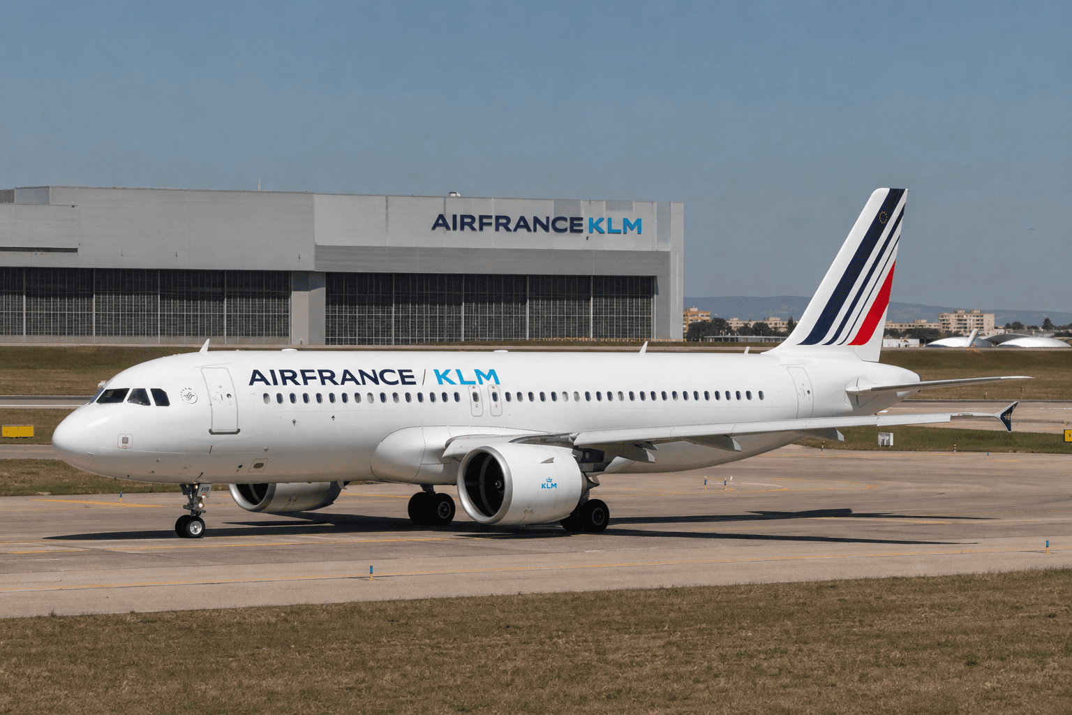 Air France-KLM aircraft at Lisbon airport with maintenance hangar in background under clear sky