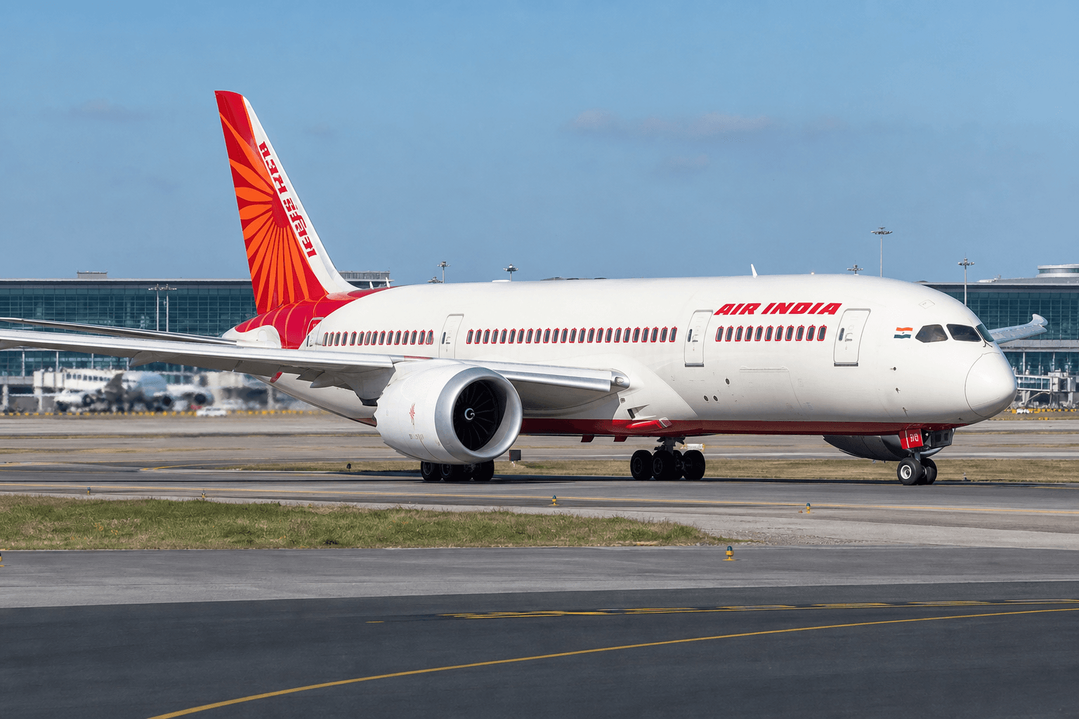 A large commercial aircraft taxiing on a runway at a major international airport in daylight.