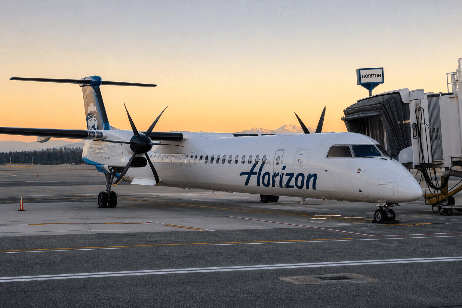 An aircraft from Horizon Air parked at a regional airport gate during early morning hours.