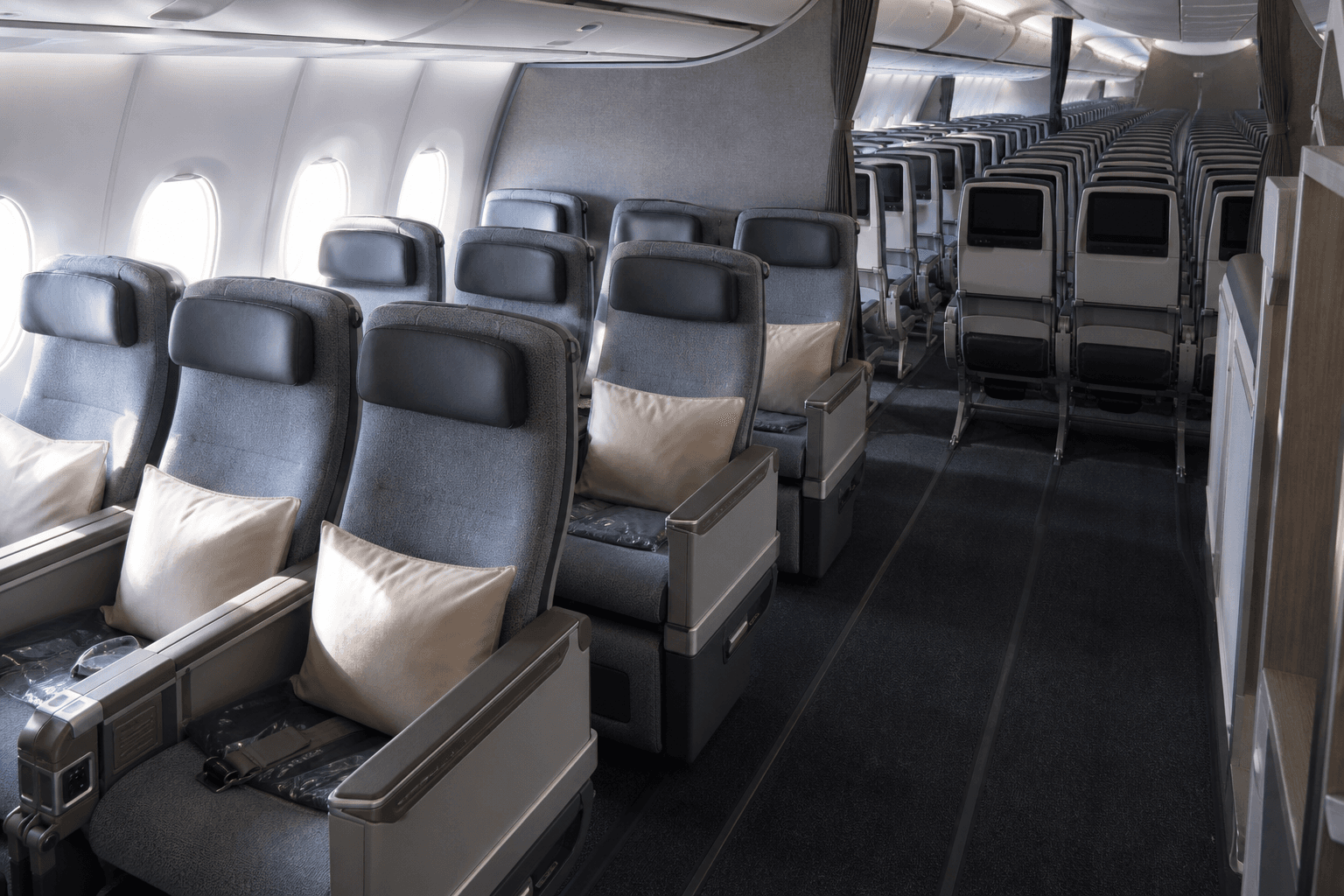 Airplane cabin showing contrast between spacious premium seats and compact economy seating