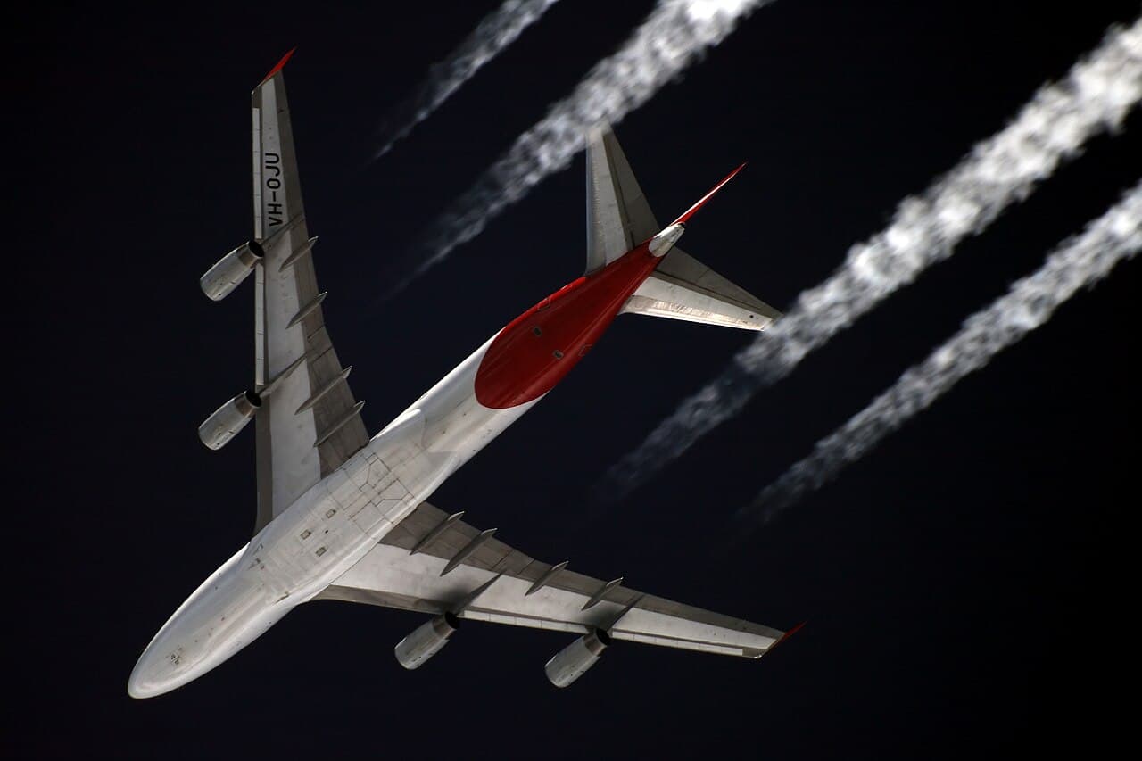 Boeing 747-8 on tarmac undergoing modifications with service vehicles nearby