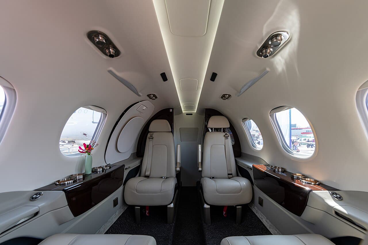 Phenom 300EV business jet on runway preparing for takeoff under clear sky
