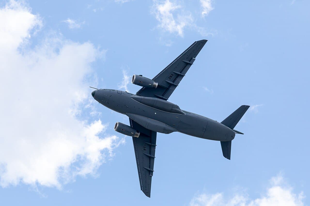 Embraer KC-390 tactical airlifter landing on a rugged airstrip at dusk