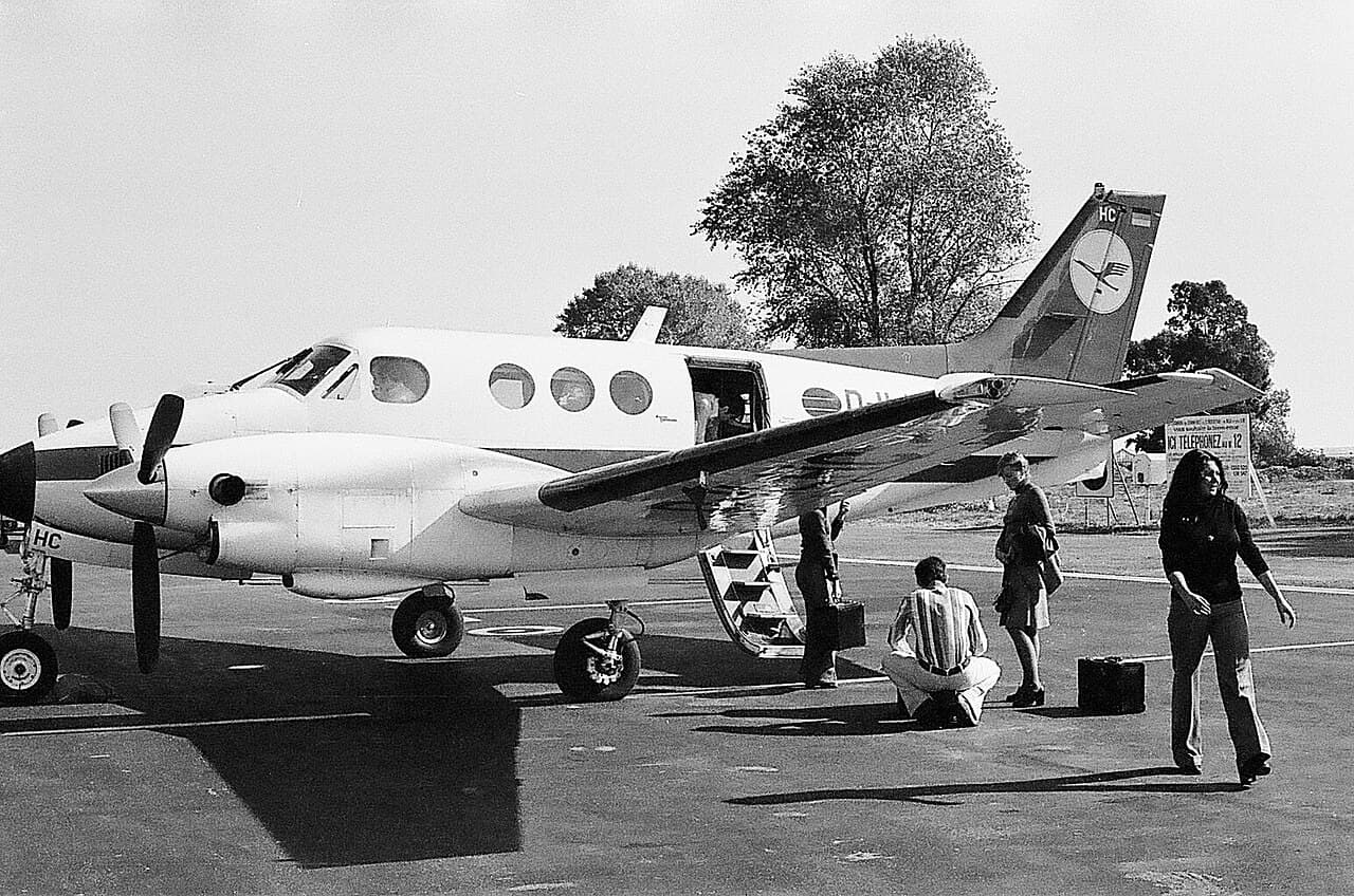 A Beechcraft King Air flying near mountainous terrain at night