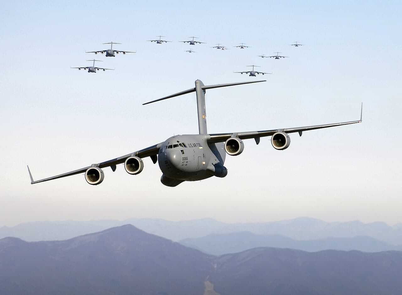 C-17 Globemaster III tactical airlifter taxiing at a military base runway under clear sky