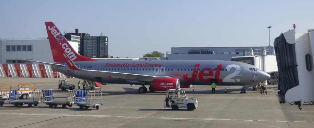 Jet2 aircraft taxiing at Bournemouth Airport with terminal in background during daytime