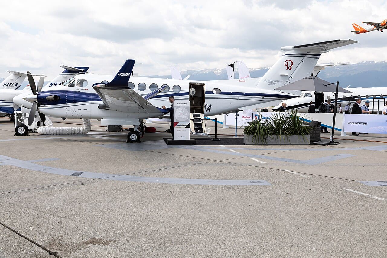 Beech King Air aircraft flying over mountainous terrain at night