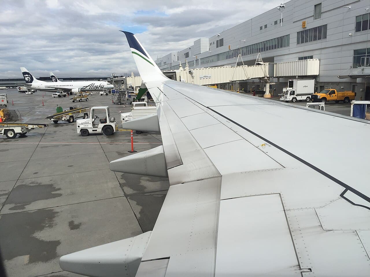 Widebody aircraft parked near a hangar under construction at Portland International Airport on an overcast day