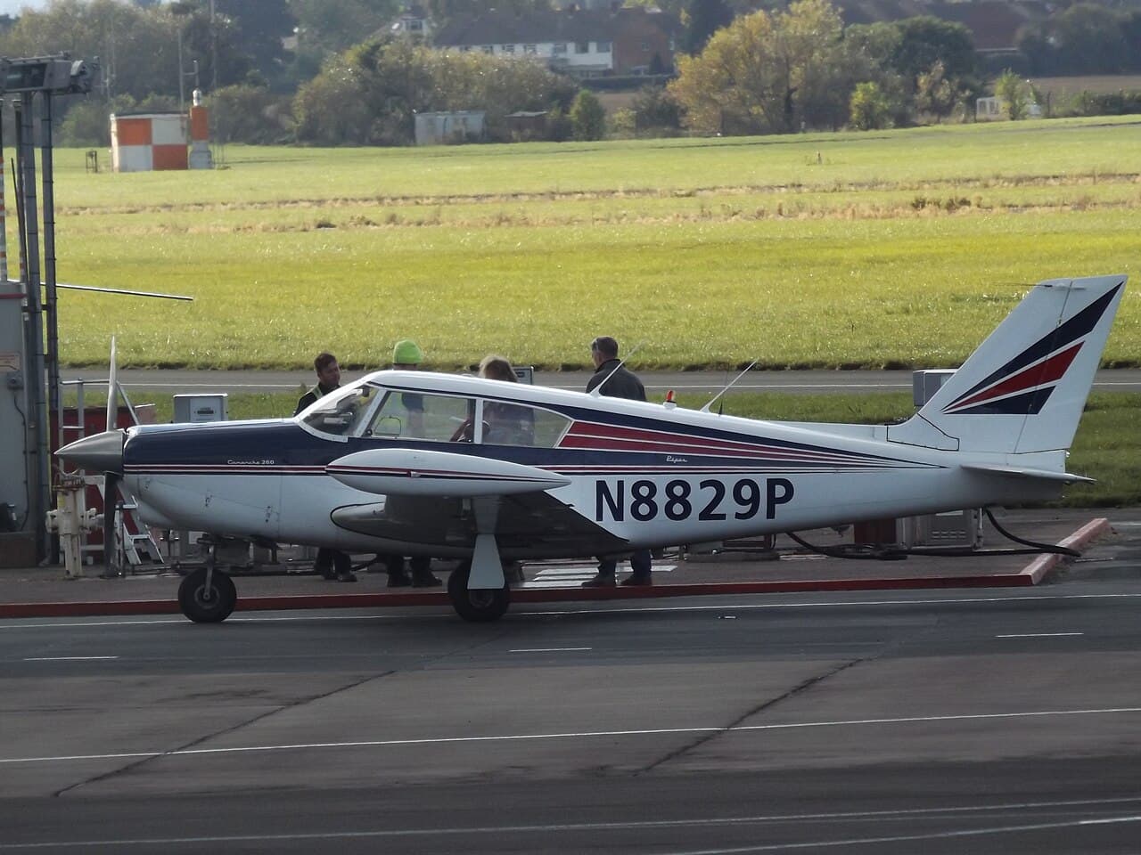 Piper PA-24-250 Comanche parked on an apron under clear skies with classic livery