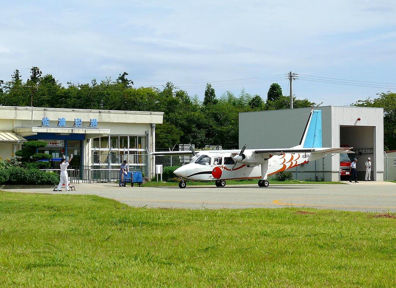 ATR 42-600 turboprop aircraft taxiing at a small Japanese regional airport runway in daylight