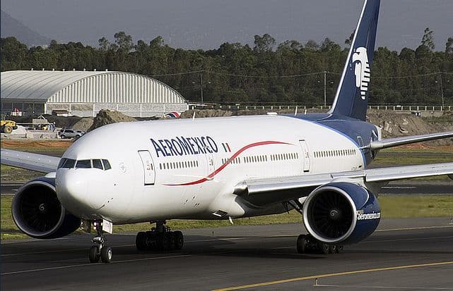 Commercial aircraft from various global airlines parked at airport gates during the day
