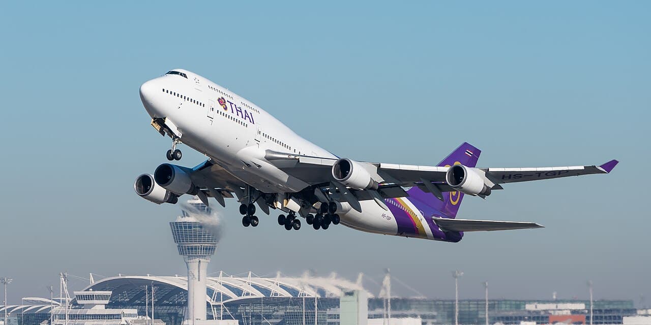 A Boeing 747-8 in flight showing its distinctive raked wingtips under bright daylight