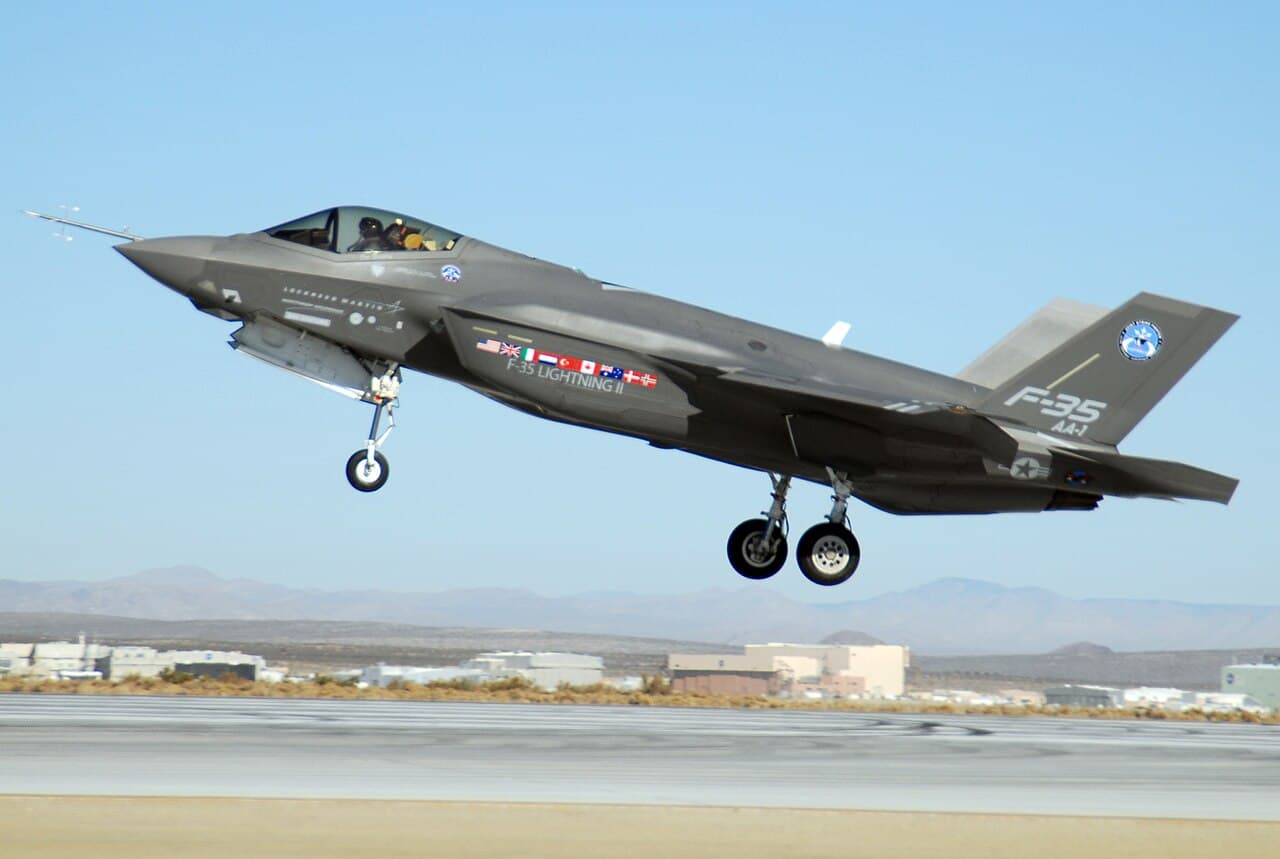 F-35 fighter jet parked on Eglin Air Force Base ramp with maintenance crews nearby at dusk