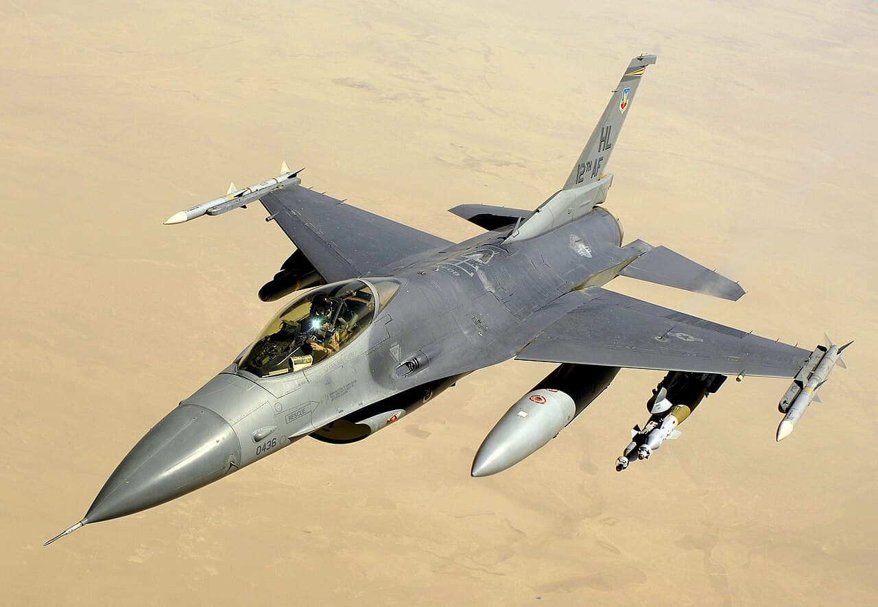 F-16 fighter jet on runway at dusk showing radar nose cone