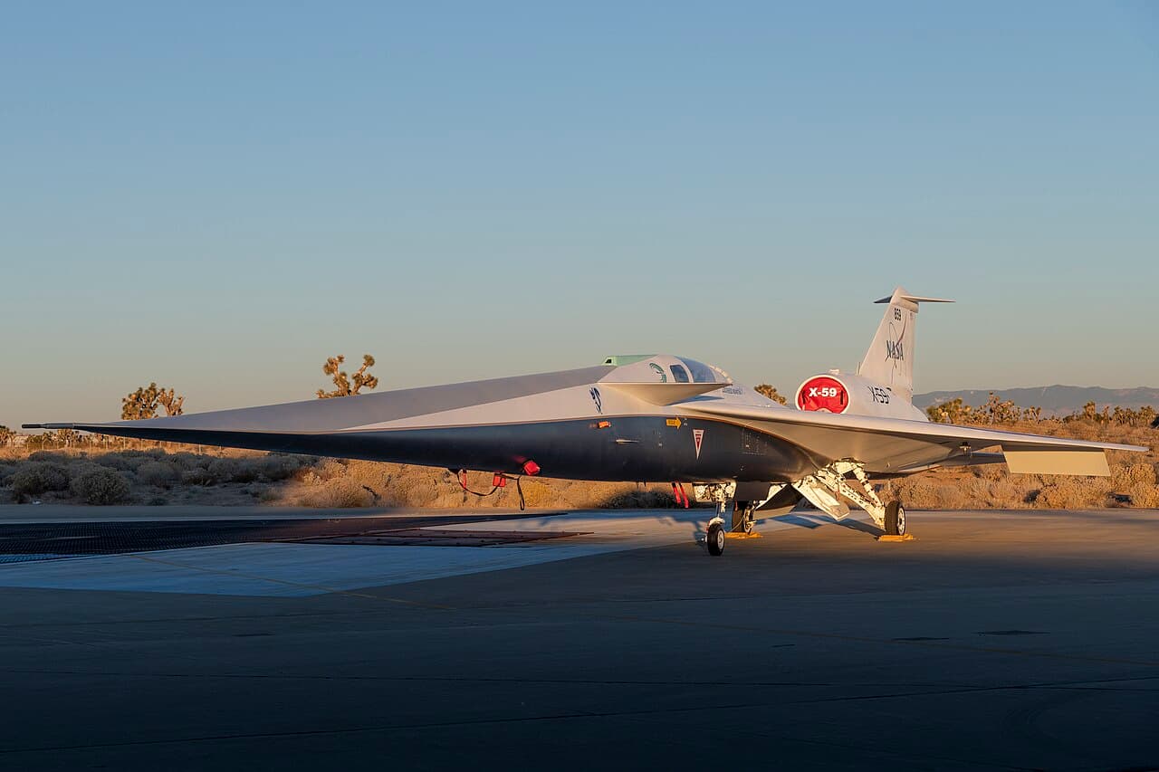 NASA X-59 supersonic demonstrator flying at high altitude with clear blue sky background